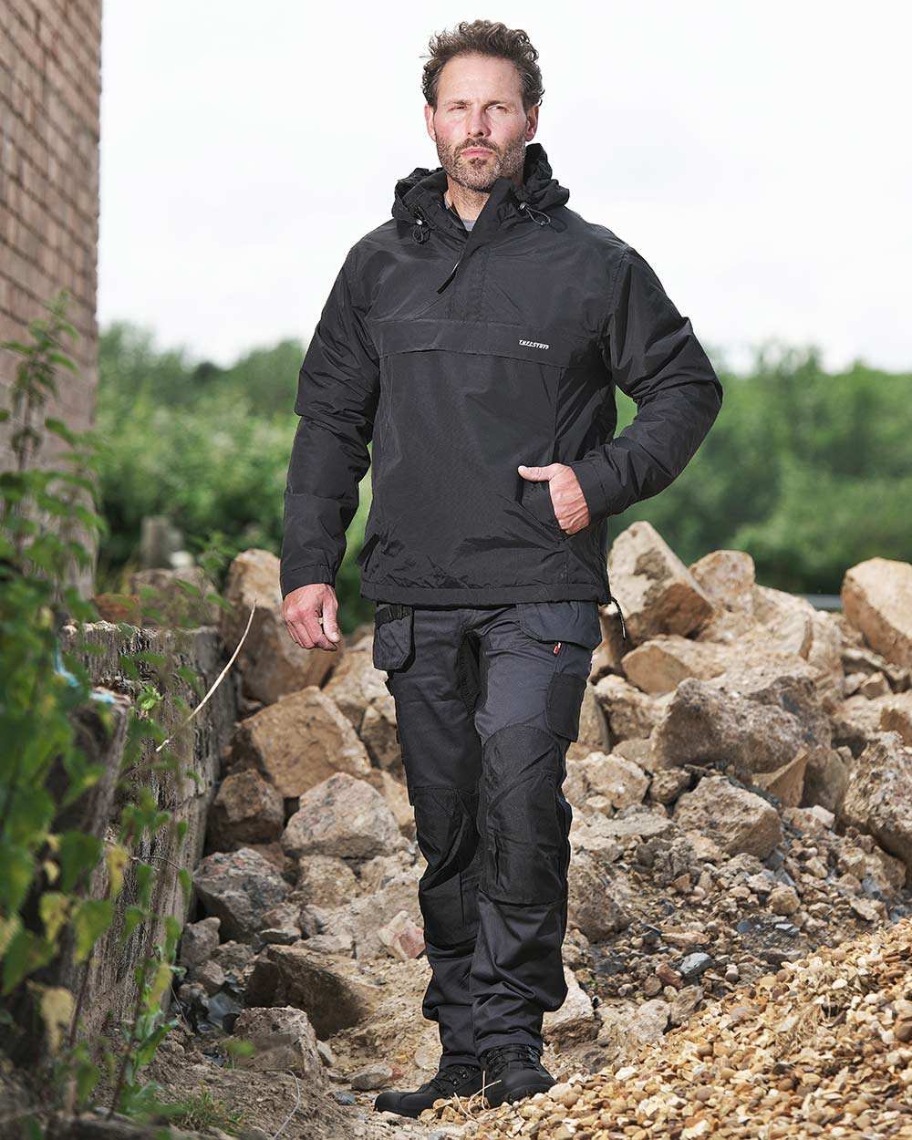 Grey Coloured TuffStuff X Motion Work Trousers On A Rock Background