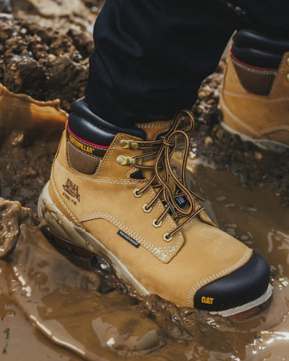 Honey Coloured Caterpillar Spiro Waterproof Safety Boot On A Mud Background 