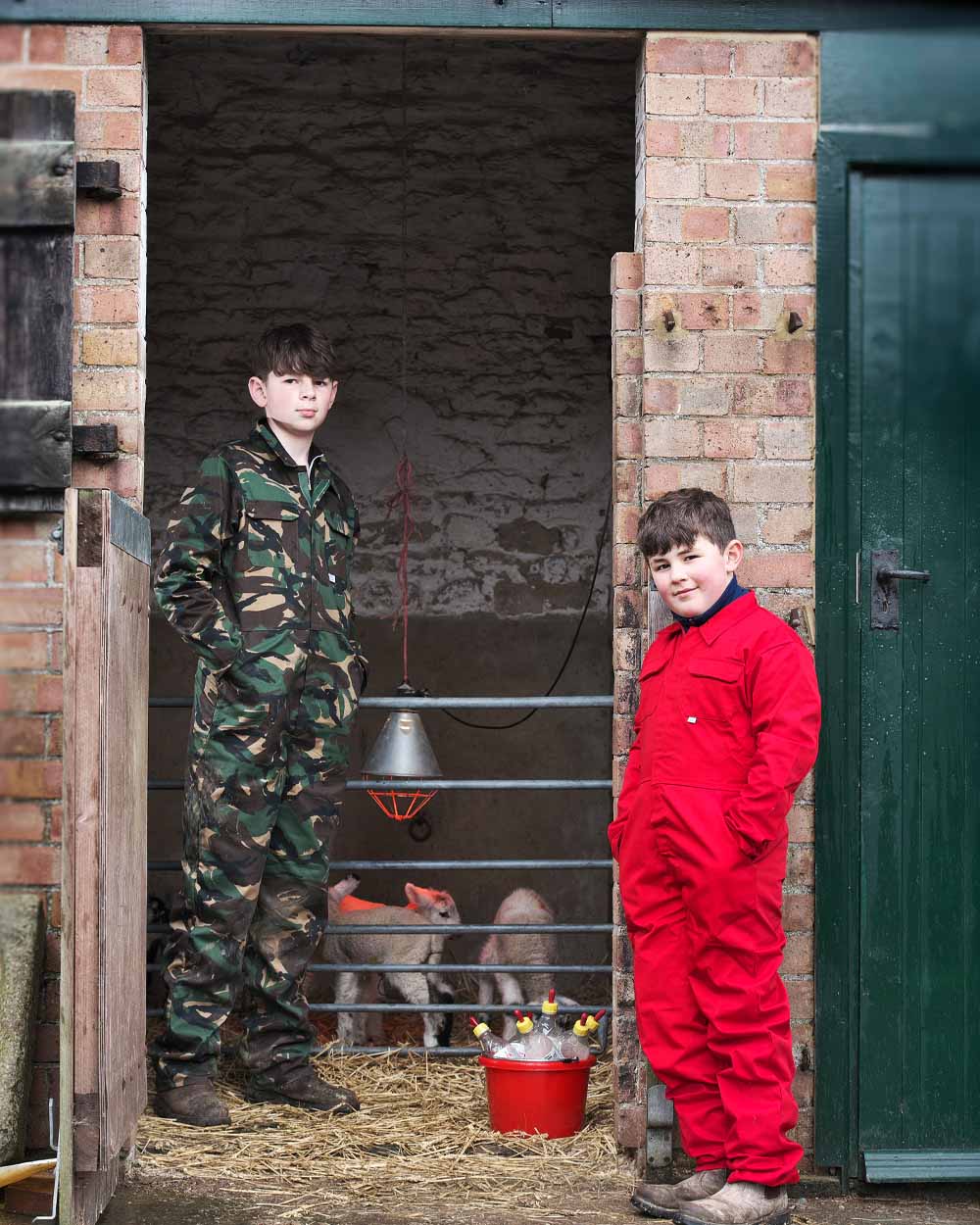 Red &amp; Woodland coloured Fort Tearaway Junior Coverall on Farm background 