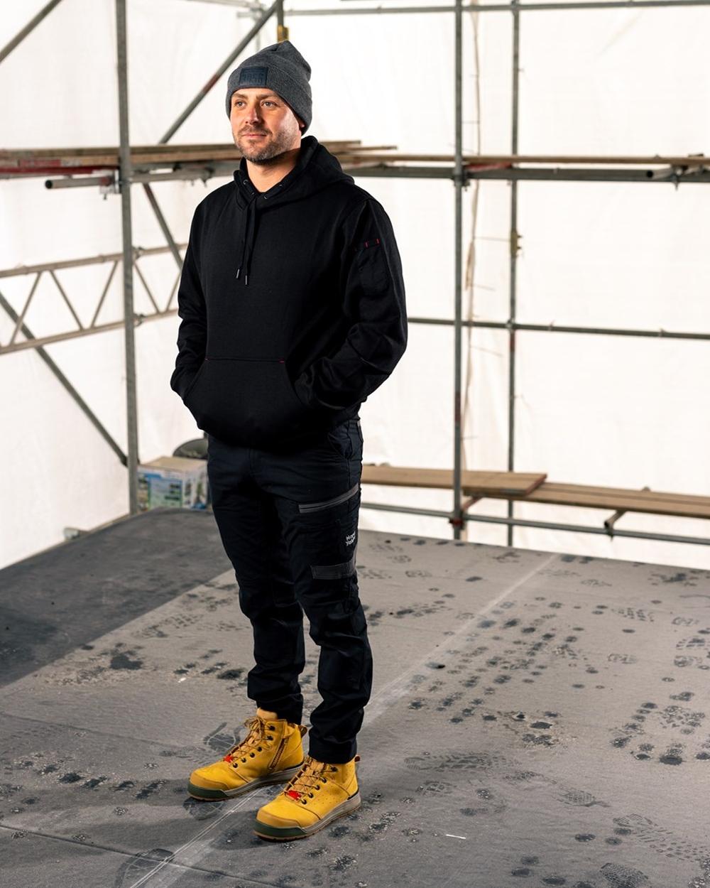 Black Coloured Hard Yakka Mens Brushed Fleece Hoodie on Construction Background

