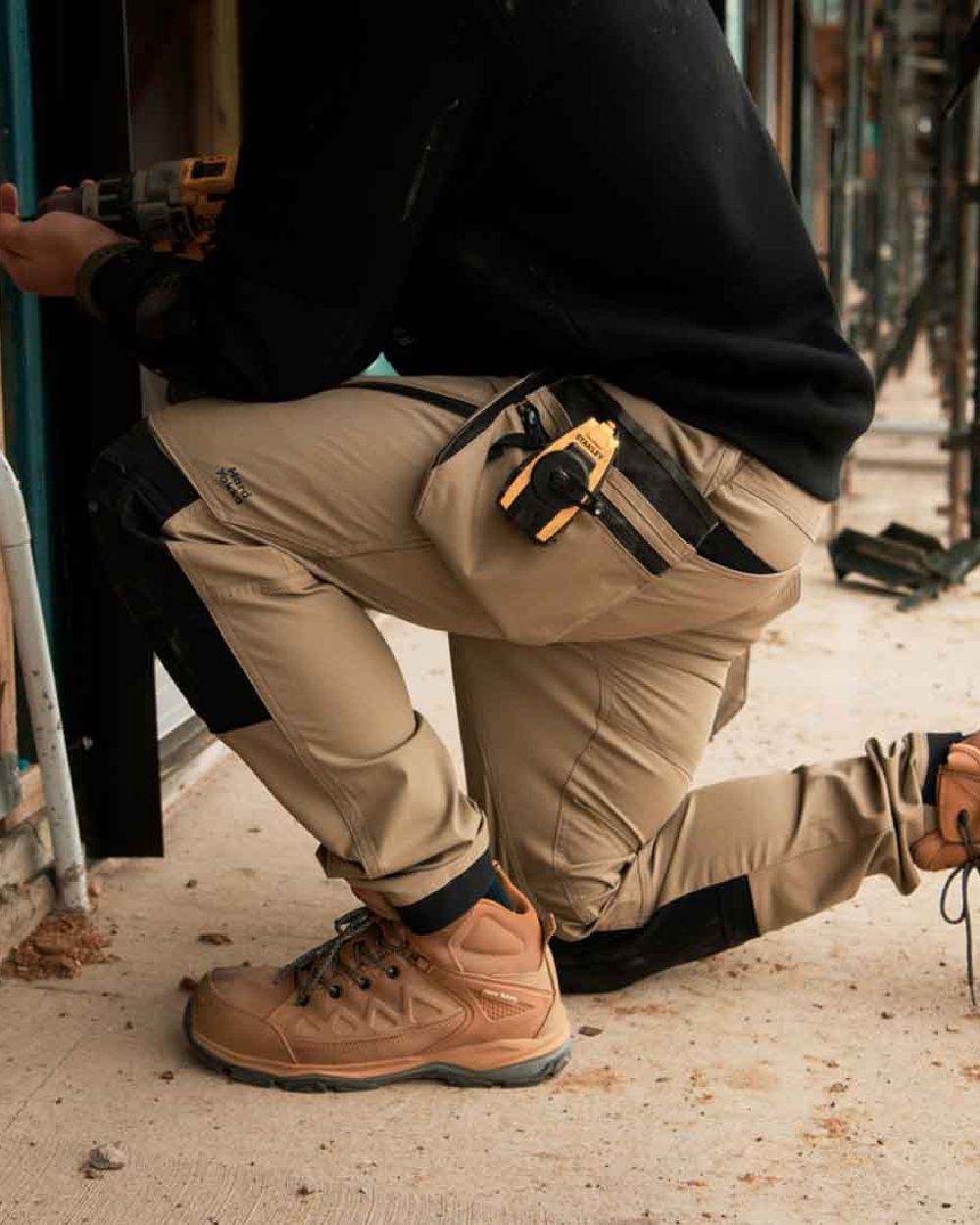 Desert Coloured Hard Yakka Mens Raptor Active Trousers on Construction Background
