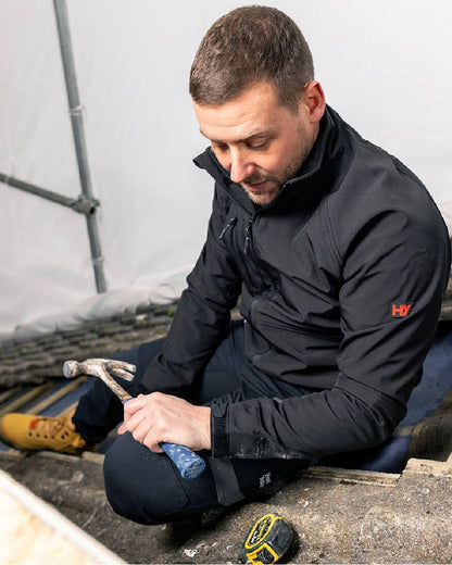 Black Coloured Hard Yakka Mens Toughmaxx Water Resistance Jacket on Work Station Background
