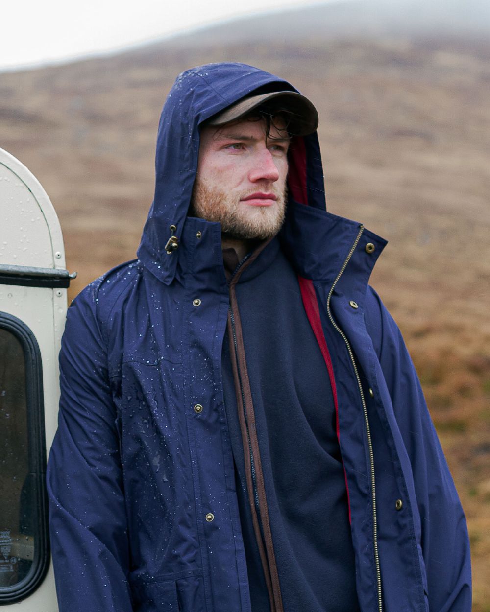 Navy coloured Hoggs of Fife Culloden Waterproof Field Jacket on mountain background 