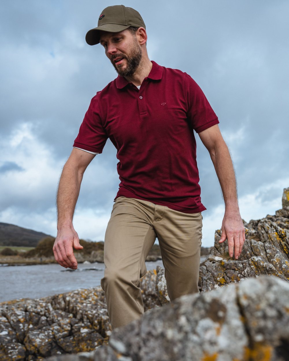 Bordeaux coloured Hoggs of Fife Largs Pique Polo Shirt on mountain background 