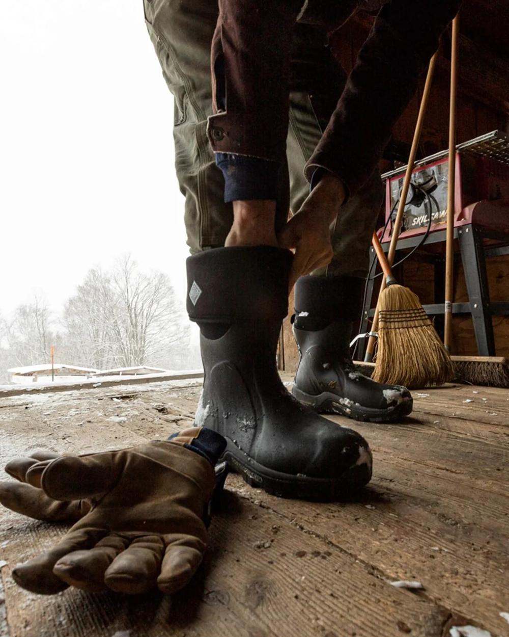 Black Coloured Muck Boots Arctic Sport Tall Wellingtons On A Shelter Background 