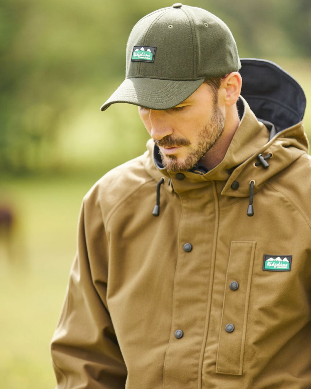 Teak coloured Ridgeline Monsoon Classic Jacket on Blurry Green background 