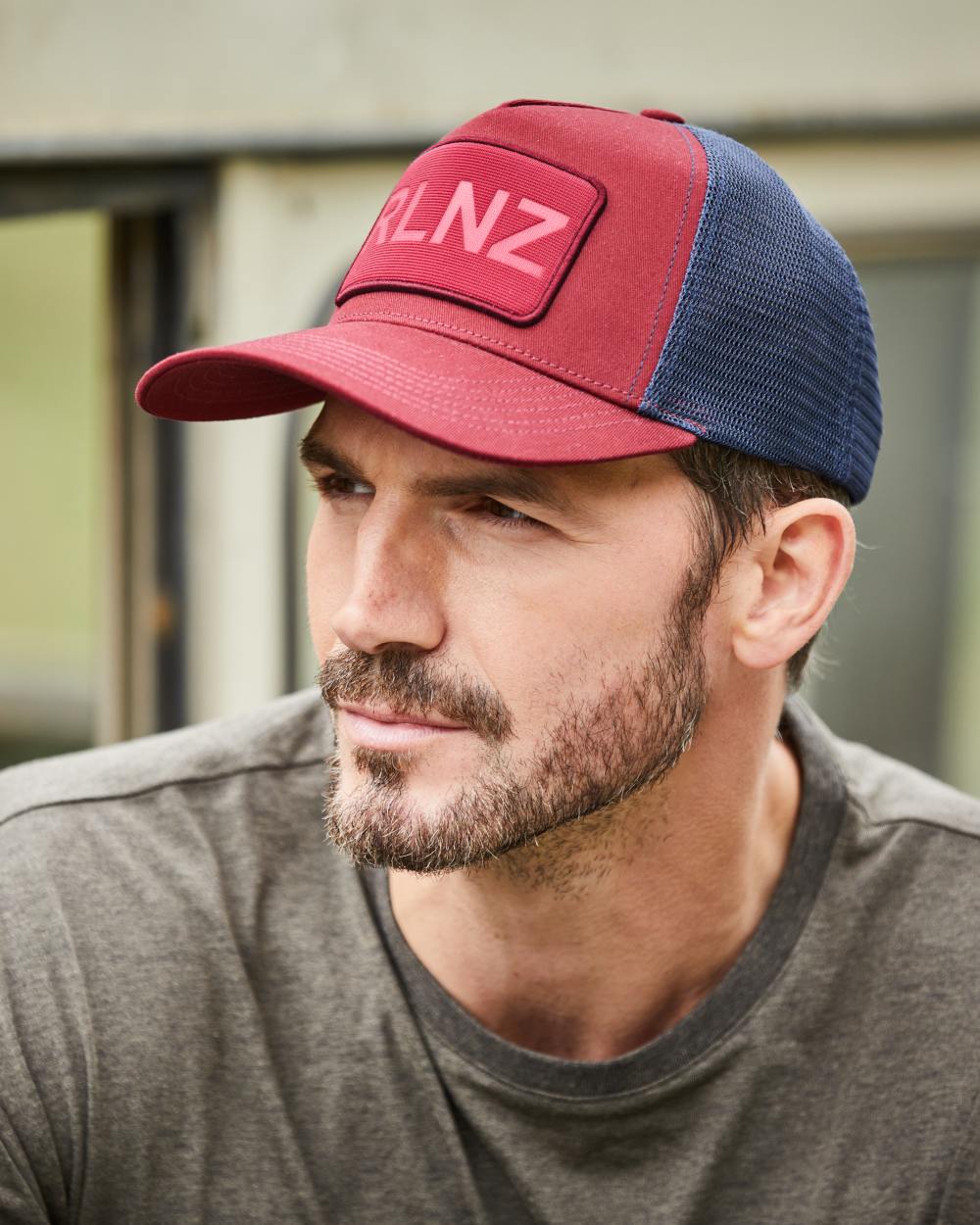 Rhubarb Coloured Ridgeline RLNZ Trucker Cap on outdoor background 