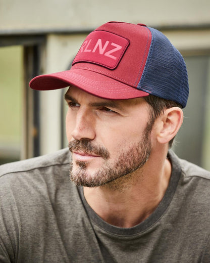 Rhubarb Coloured Ridgeline RLNZ Trucker Cap on outdoor background 
