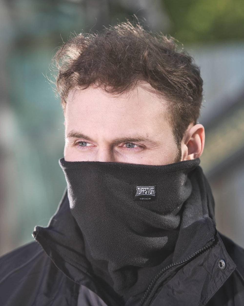 Black Coloured TuffStuff Pro Neck Warmer On A Street Background