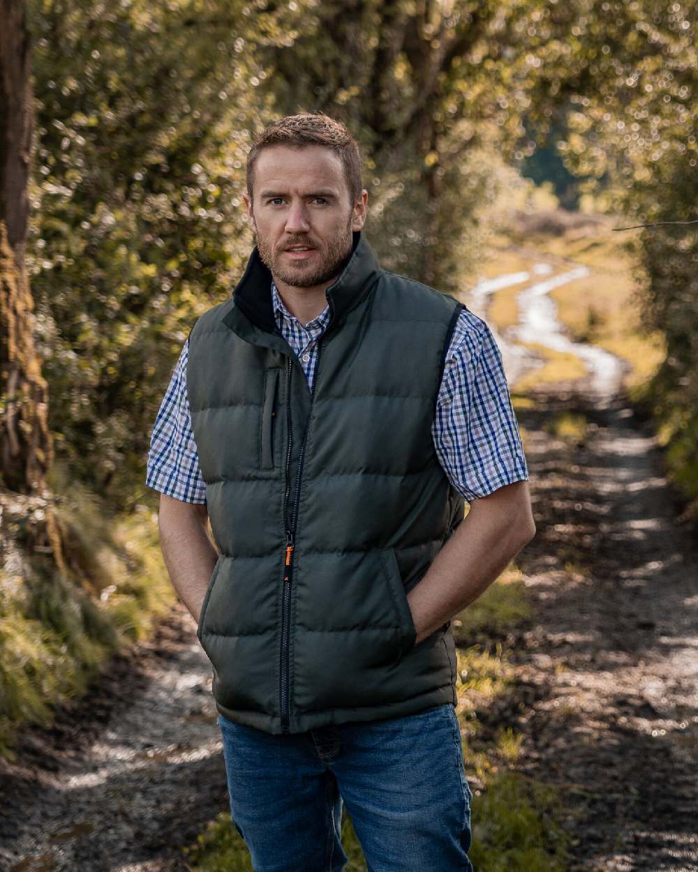 Green Coloured Xpert Mens Core Padded Work Bodywarmer on Forest Background
