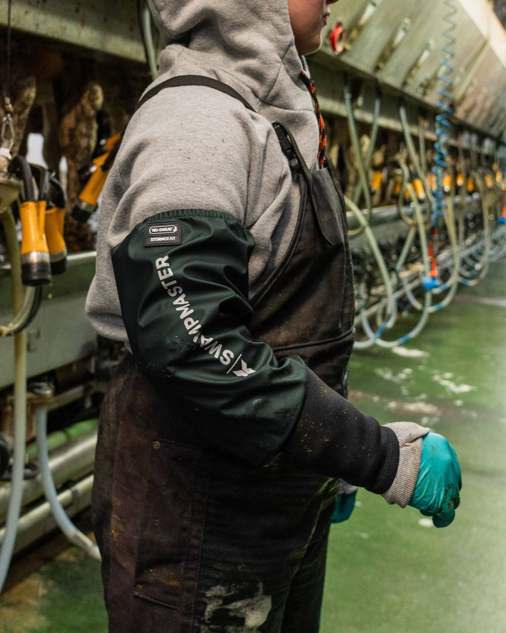 Green Coloured Xpert Swampmaster Stormgear Waterproof Dairy Sleeves on Factory Background
